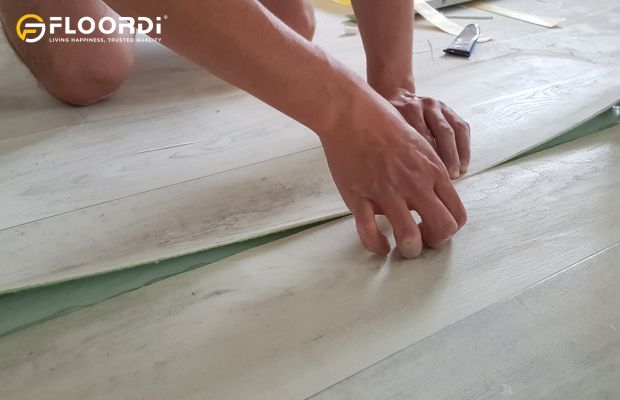 Installing linoleum flooring in light wood pattern over green underlayment